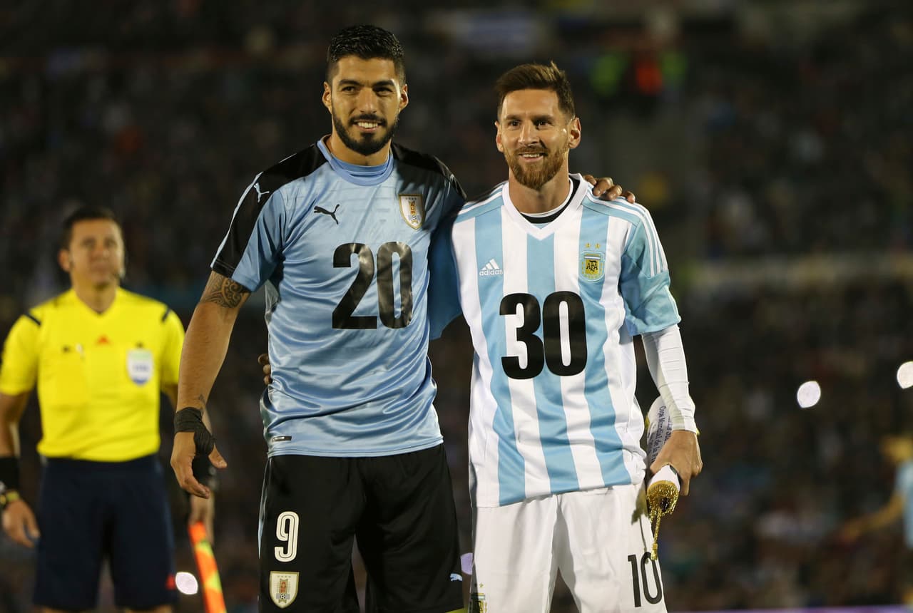 Argentina's Lionel Messi and Uruguay's Luis Suarez pose for pictures wearing the number 20 and 30 as the support the candidacy of Uruguay and Argentina for the 2030 World Cup before a 2018 World Cup qualifying soccer match in Montevideo, Uruguay, Thursday, Aug. 31, 2017.(AP Photo/Natacha Pisarenko)