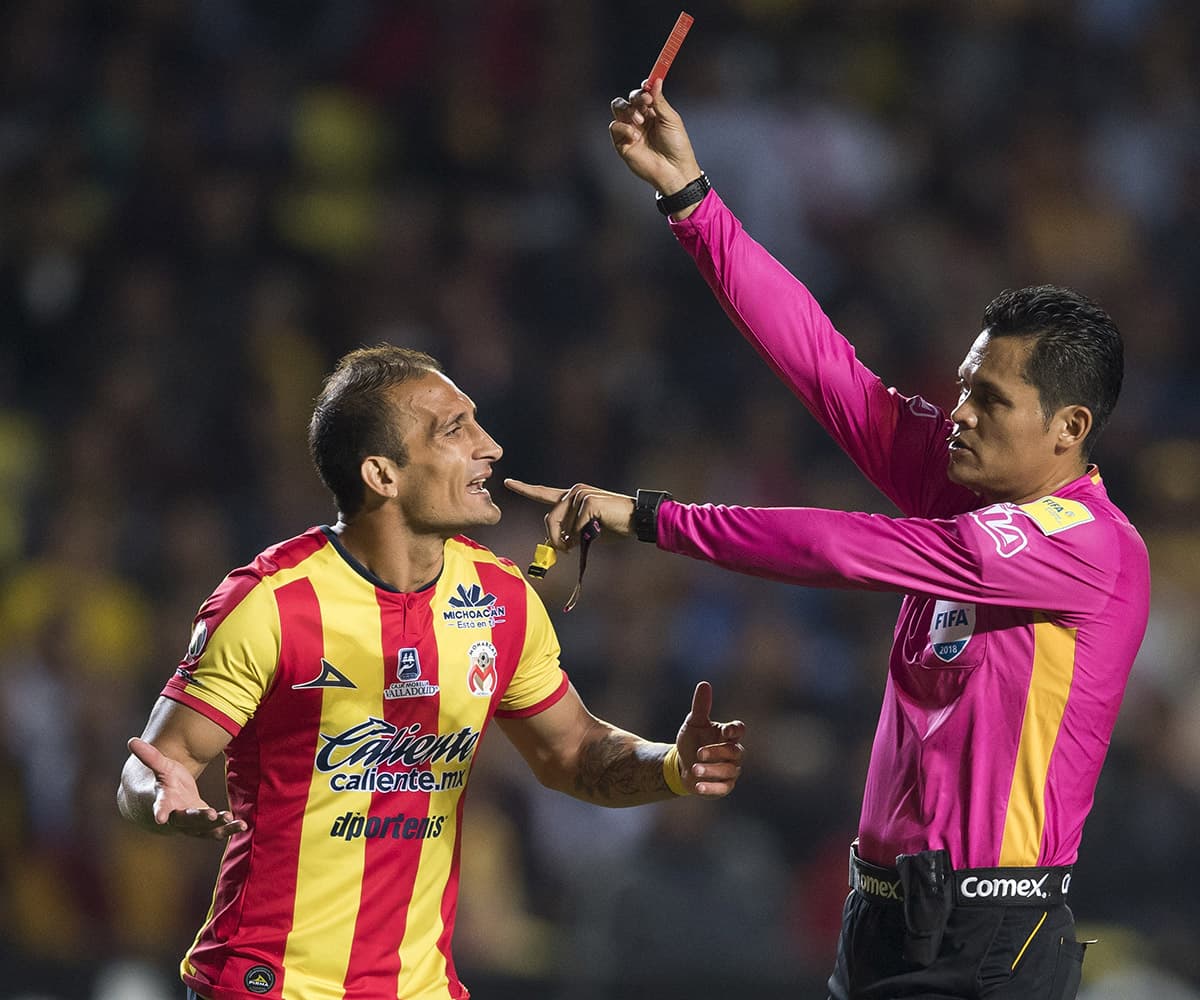 Luego de revisar la acción, el silbante Jorge Antonio Pérez (derecha) expulsó al ecuatoriano Gabriel Achilier de Morelia (fuera de la foto).