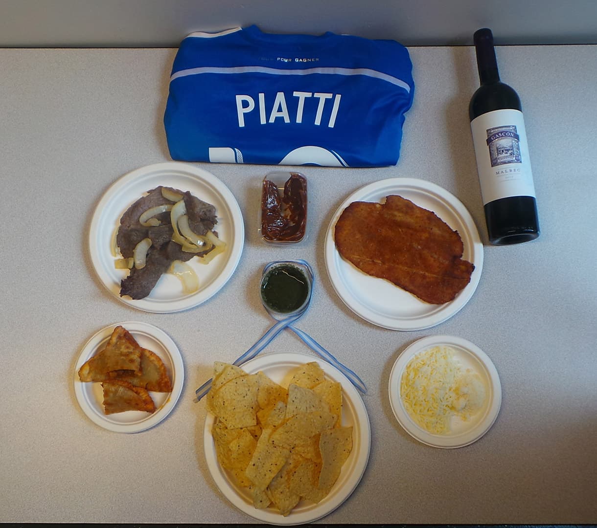 Aquí te dejamos todos los ingredientes de los NACHOS PIATTI. Nachos, Milanesa, Carne Asada, Empanadas, Queso, Chimichurri, y por supuesto un delicioso Malbec de Mendoza.