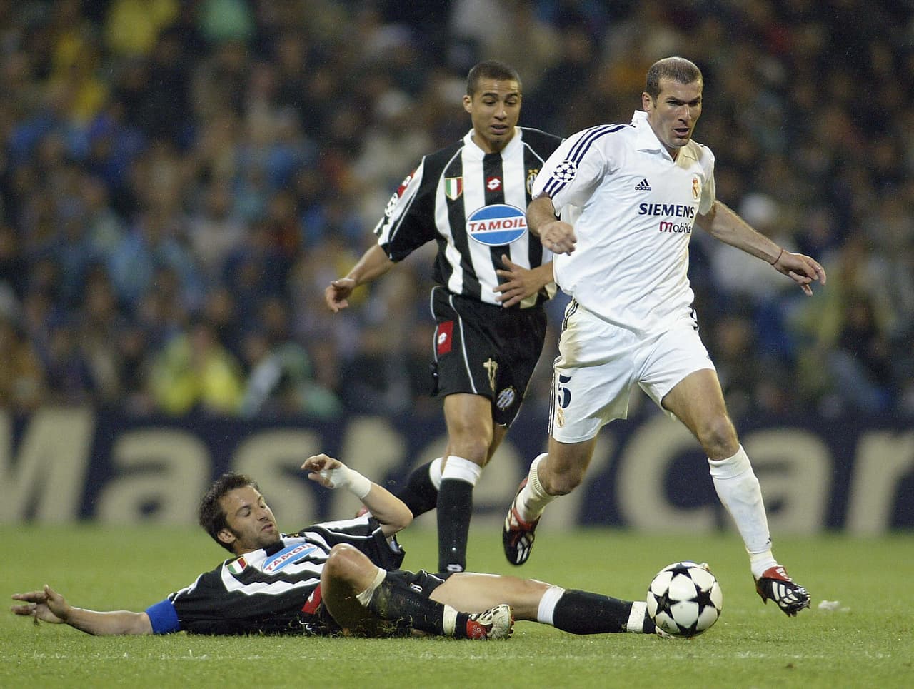 Real Madrid's Zinedine Zidane (R) escapes with the ball in front of Juventus' Alessandro del Piero (down) and David Trezeguet during their semi final first leg Champions League match in Madrid 06 May 2003. AFP PHOTO JAVIER SORIANO (Photo credit should read JAVIER SORIANO/AFP/Getty Images)
