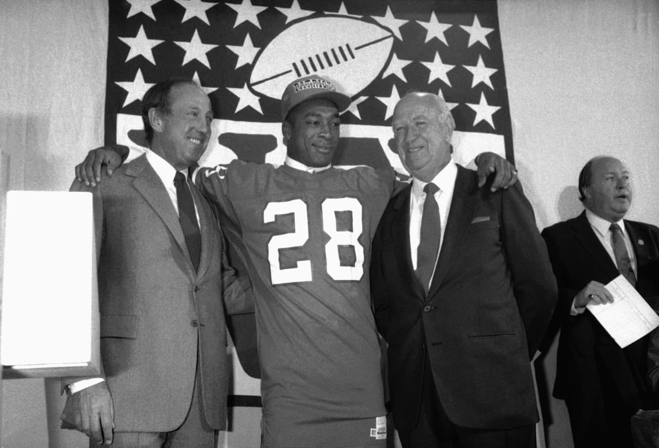 1984 IRVING FRYAR | WR Nebraska - 
<b>New England Patriots</b>
<br>
<br>El nuevo receptor abierto de los New England Patriots, Irving Fryar (28) posa para una foto con el comisionado de la NFL, Pete Rozelle, y con el dueño del equipo, Bill Sullivan, durante el Draft de la NFL el 1 de mayo de 1984 en Nueva York. Fryar fue elegido con la primera selección global.