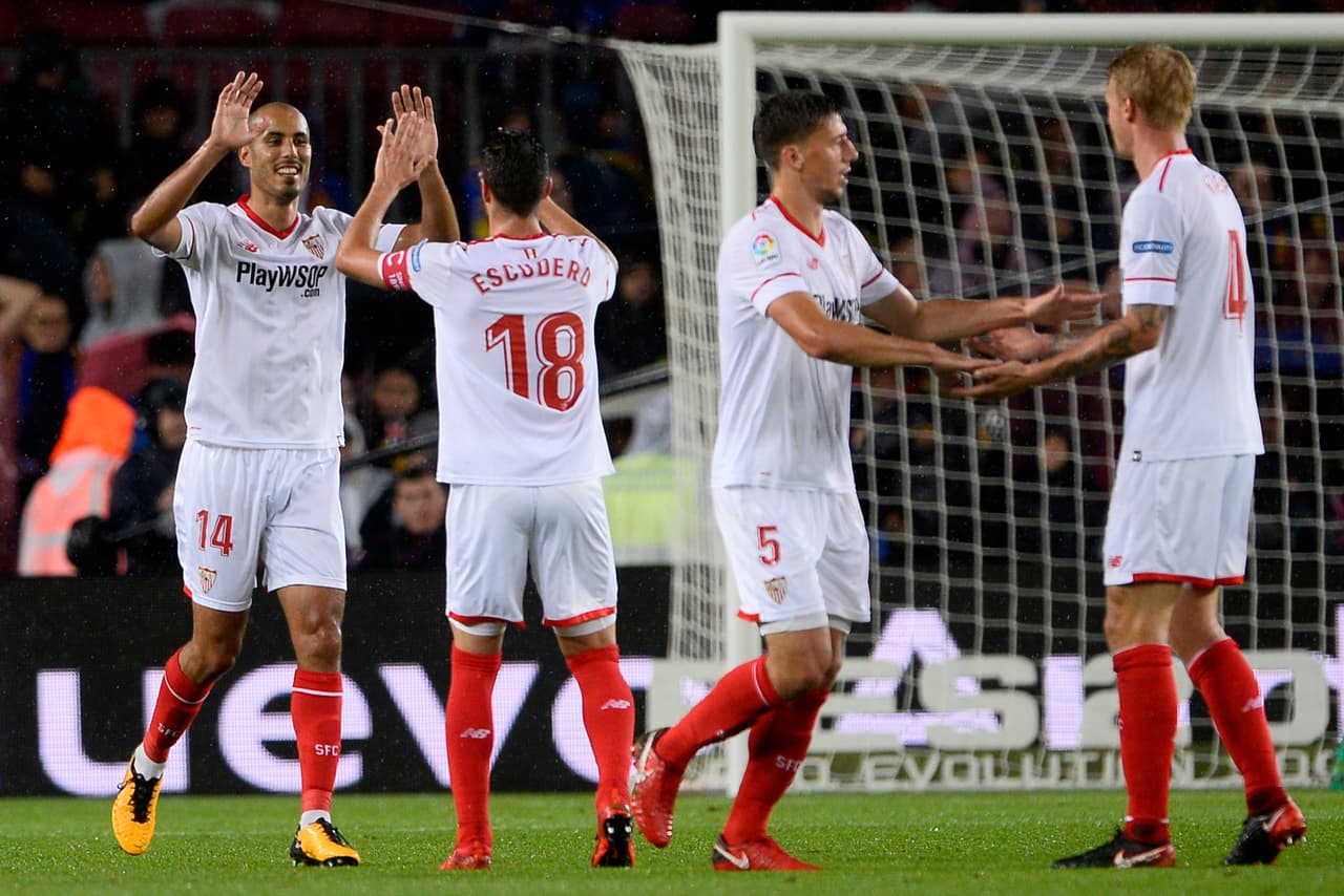 Sevilla's Argentinian midfielder Guido Pizarro (L) celebrates with teammates after scoring a goal during the Spanish league football match FC Barcelona vs Sevilla FC at the Camp Nou stadium in Barcelona on November 4, 2017. / AFP PHOTO / Josep LAGO (Photo credit should read JOSEP LAGO/AFP/Getty Images)