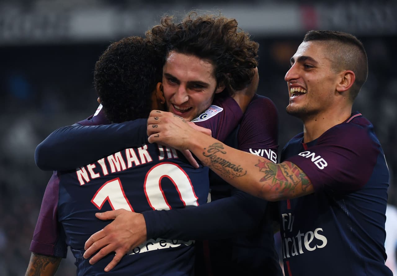 Paris Saint-Germain's Brazilian forward Neymar (L) celebrates with Paris Saint-Germain's French midfielder Adrien Rabiot (C) and Paris Saint-Germain's Italian midfielder Marco Verratti (R) after scoring a goal during the French L1 football match between Marseille (OM) and Paris Saint-Germain (PSG) on October 22, 2017, at the Velodrome Stadium in Marseille, southeastern France. / AFP PHOTO / ANNE-CHRISTINE POUJOULAT (Photo credit should read ANNE-CHRISTINE POUJOULAT/AFP/Getty Images)