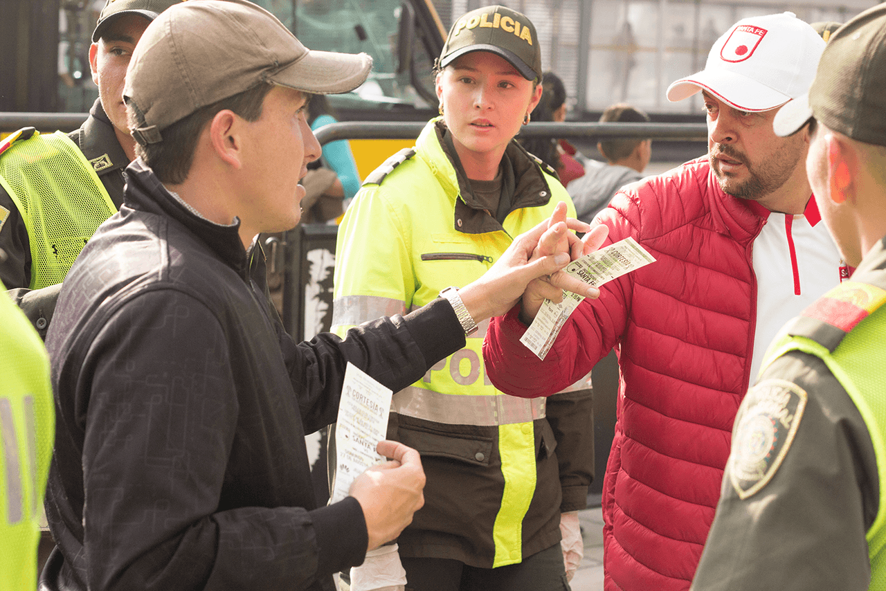 José Richard se aferra a la mano de César, quien actúa como dos de sus sentidos (vista, oído) durante los filtros de entrada al estadio.