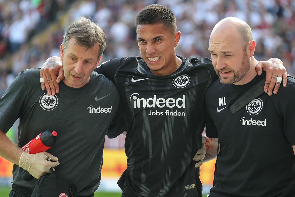 El mexicano Carlos Salcedo (centro) es ayudado para salir del campo a los 11 minutos de juego en la derrota del Eintracht Frankfurt por 2-1 contra el Werder Bremen.