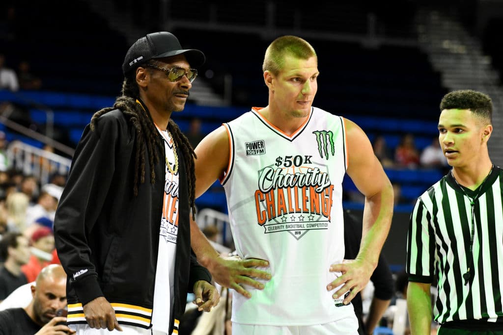 El recientemente retirado ala cerrada de los New england Patriots Rob Gronkowski (der) y el famoso cantante de rap Snoop Dogg, en los inicios del partido.