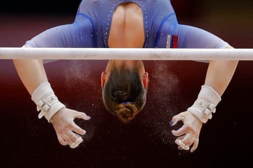 La rusa Aliia Mustafina realiza la ejecución de un ejercicio en las barras asimétricas en la final por equipos para mujeres en el Aspire Dome en Doha, Qatar.
<br>