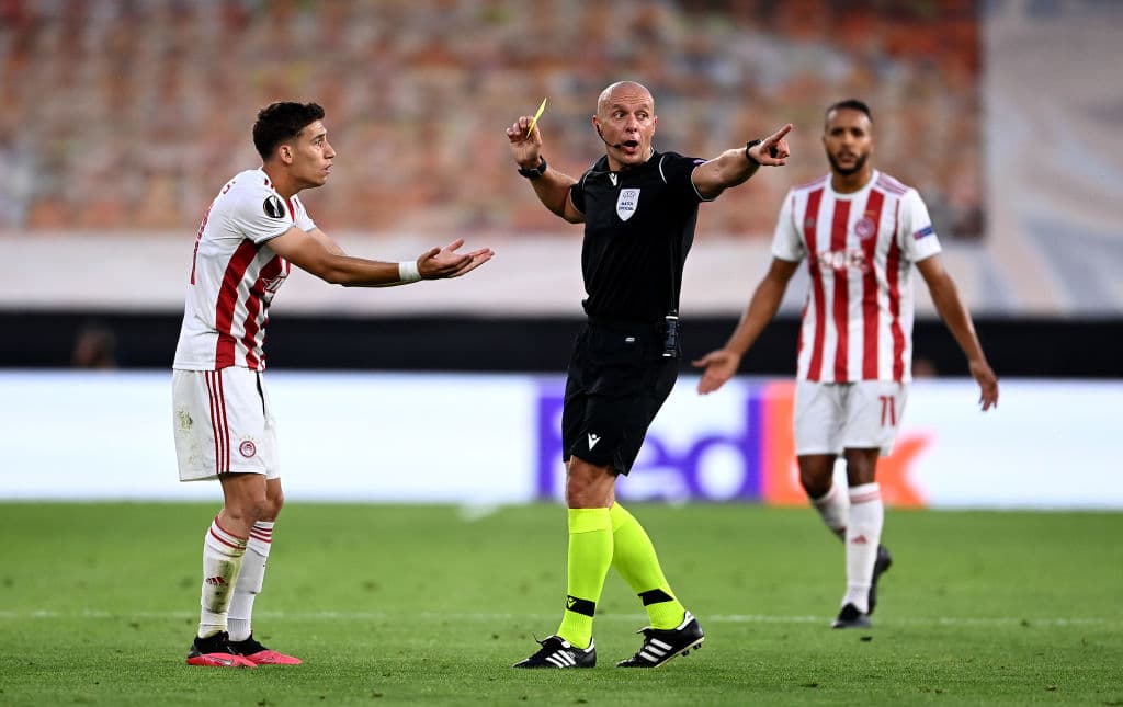 Konstantinos Tsimikas se queja luego de que el árbitro lo òntara de amarillo por una falta leve.