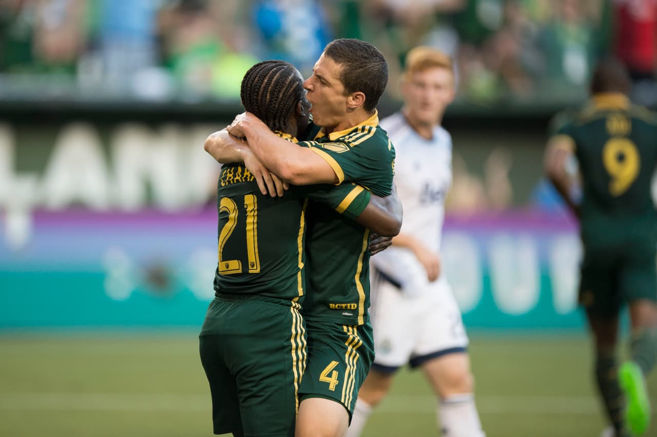 El colombiano Diego Chará y el canadiense Will Johnson celebran el gole de Valeri con Portland Timbers en duelo que terminó empatado 1-1 con Vancouver Whitecaps.