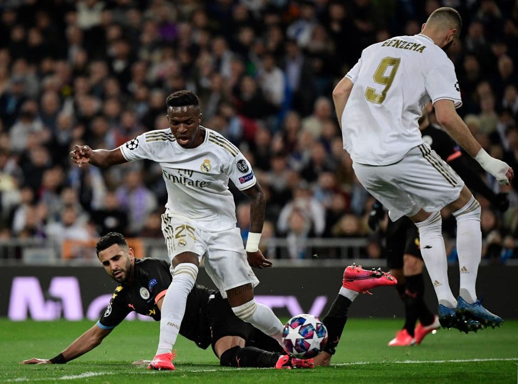 Vinícius logra dejar atrás al jugador del Manchester City Riyad Mahrez y saca el centro, pero es cortado por Aymeric Laporte.