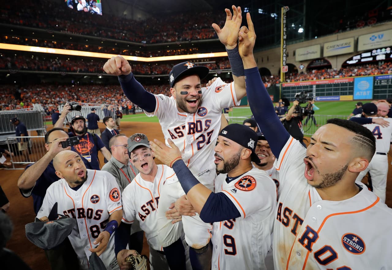 El venezolano José Altuve, de los Astros de Houston, es alzado en hombros por sus compañeros, tras la victoria sobre los Yanquis de Nueva York en la Serie de Campeonato de la Liga Americana, el sábado 21 de octubre de 2017 (AP foto/David J. Phillip)