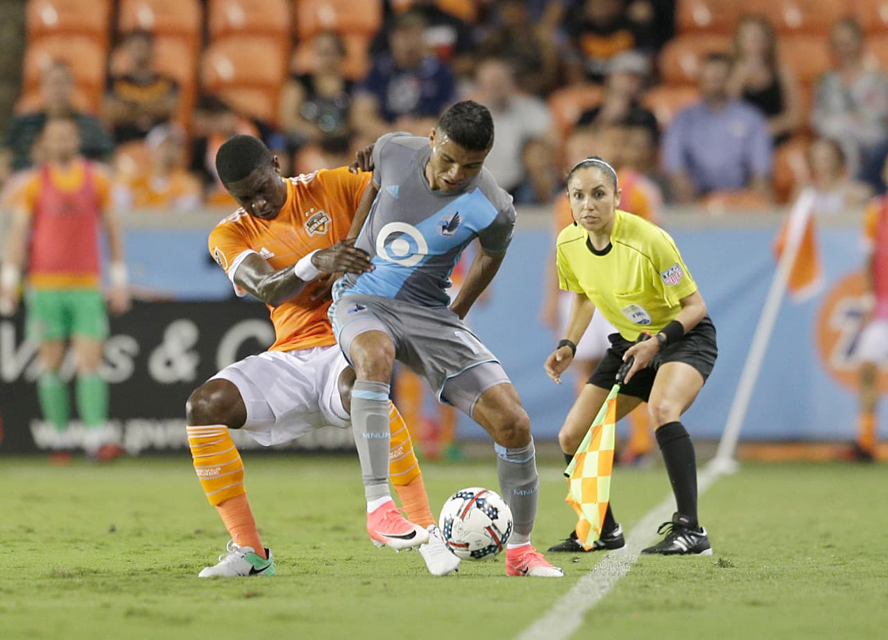 Apr 15, 2017; Houston, TX, USA; Houston Dynamo defender Jalil Anibaba (2) and Minnesota United midfielder Johan Venegas (11) fight for possession as Minnesota United head coach Adrian Heath watches in the first half at BBVA Compass Stadium. Dynamo tied the United 2 to 2. Mandatory Credit: Thomas B. Shea-USA TODAY Sports
