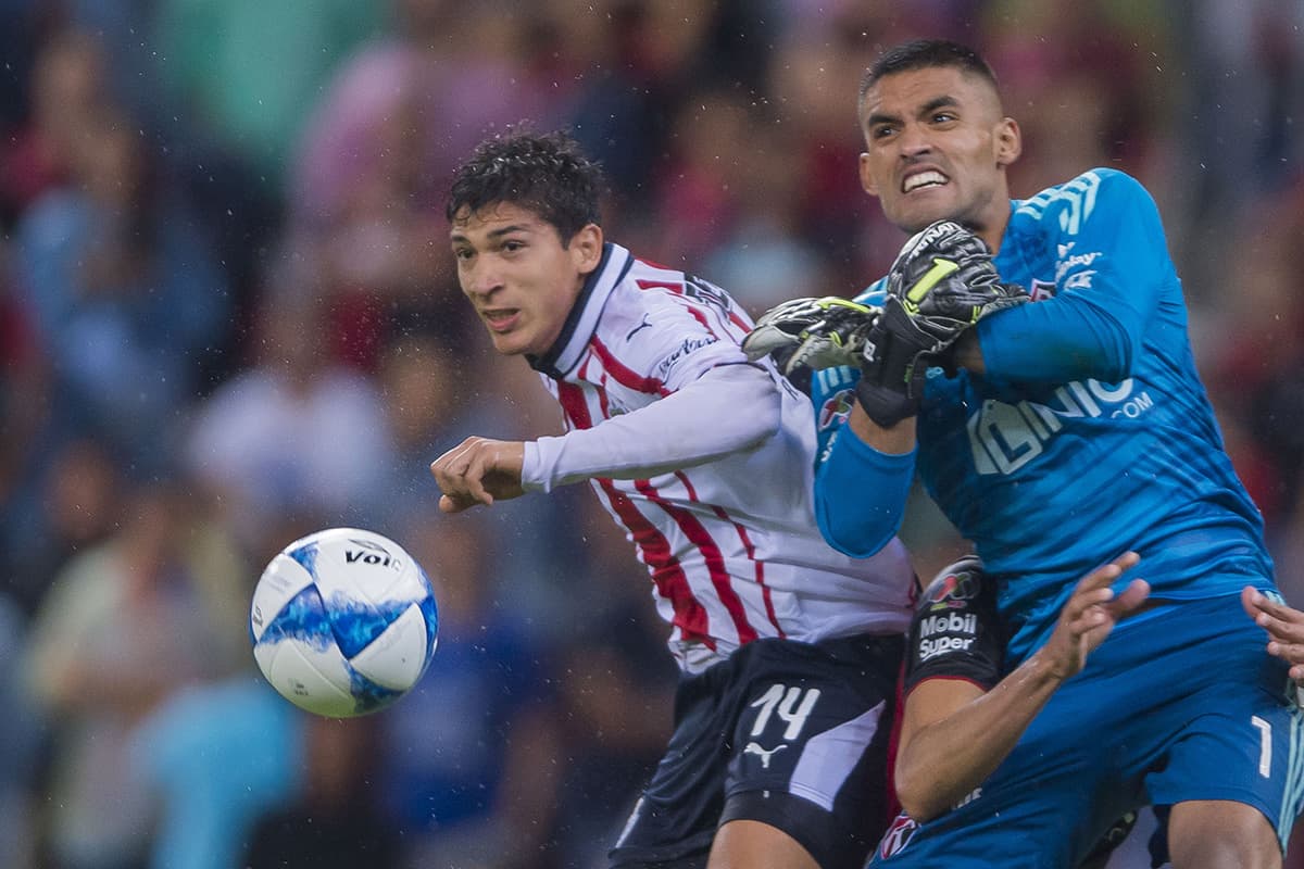 El arquero de Atlas, José Hernández (derecha), corta una jugada de riesgo chocando con el delantero de Chivas Ángel Zaldivar (izquierda).