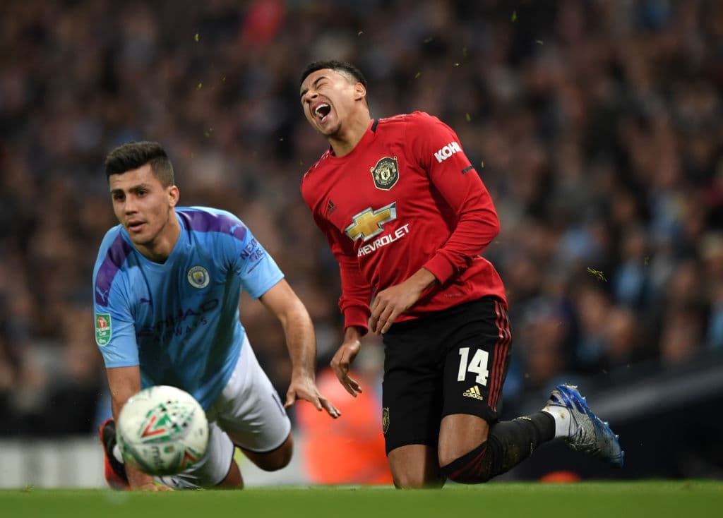 Jesse Lingard del Manchester United reacciona después de una gran entrada de Rodrigo del Manchester City.