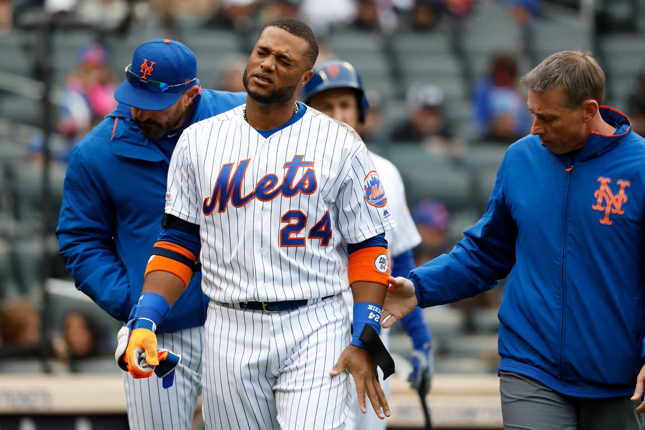 Robinson Cano #24 of the New York Mets reacts after getting hit on a foul tip in the first inning against the Milwaukee Brewers at Citi Field on April 28, 2019 in the Flushing neighborhood of the Queens borough of New York City.