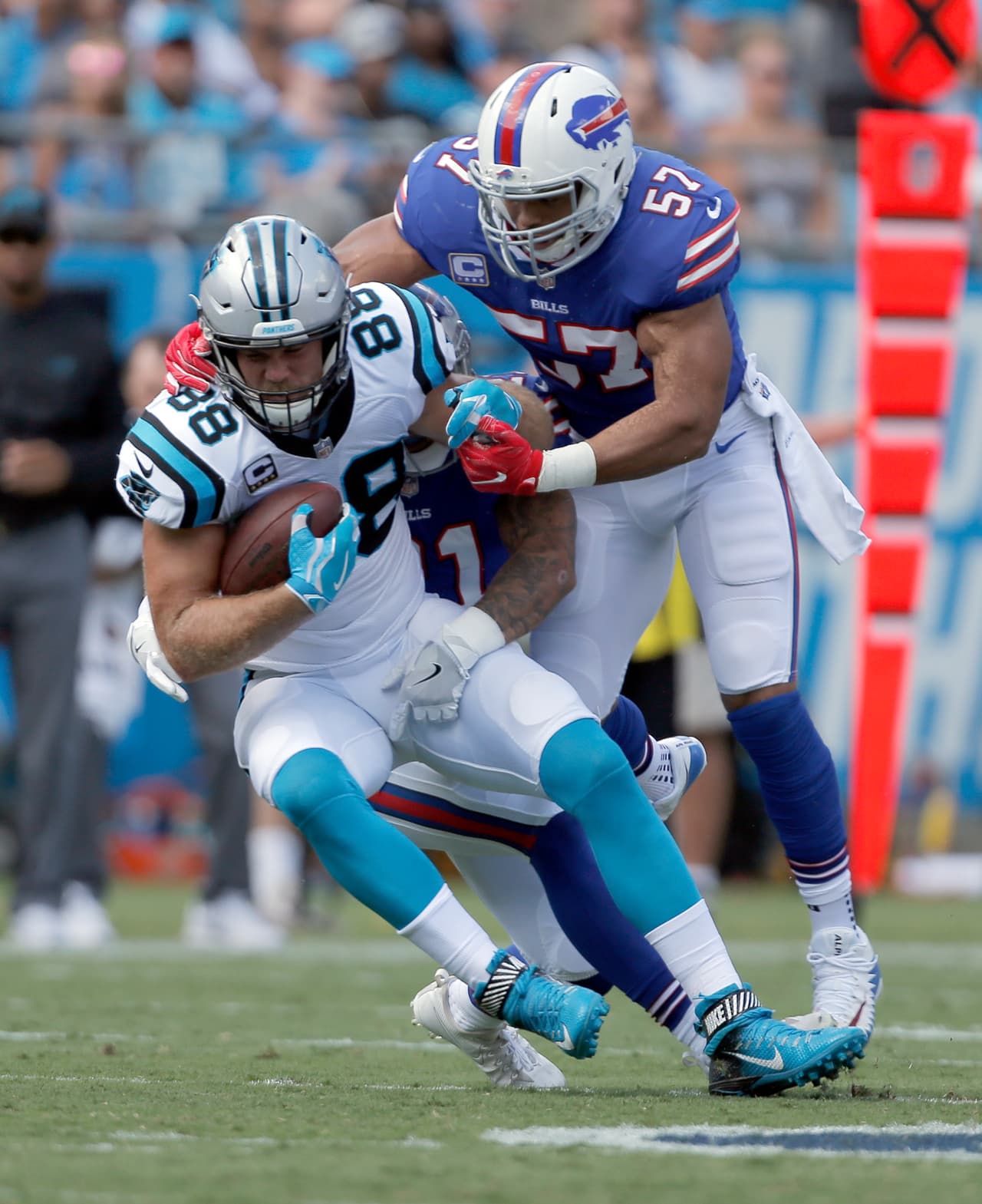 Carolina Panthers' Greg Olsen (88) is tackled by Buffalo Bills' Lorenzo Alexander (57) in the first half of an NFL football game in Charlotte, N.C., Sunday, Sept. 17, 2017. (AP Photo/Bob Leverone)