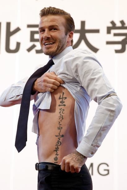 David Beckham muestra su tatuaje a los aficionados durante su visita a la Universidad de Pekín.