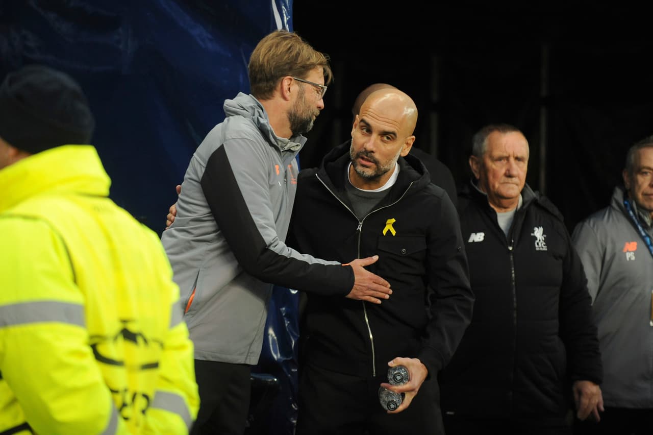 Liverpool manager Juergen Klopp, left, speaks with Manchester City manager Pep Guardiola before the Champions League quarterfinal second leg soccer match between Manchester City and Liverpool at Etihad stadium in Manchester, England, Tuesday, April 10, 2018. (AP Photo/Rui Vieira)