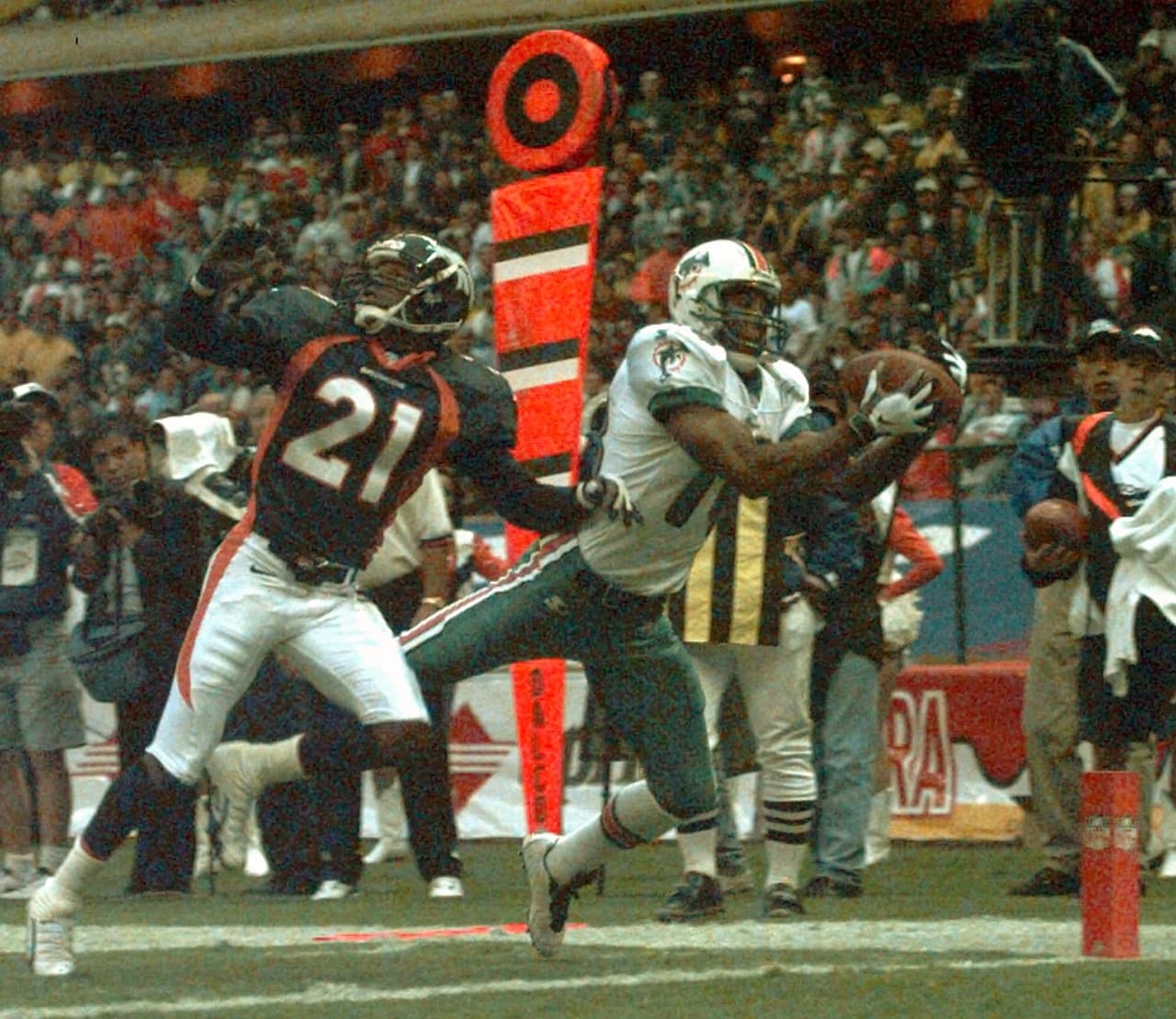 El receptor de Miami, Brian Manning (18) a la derecha, atrapa un touchdown frente al esquinero de Denver, Randy Hilliard (21), en el American Bowl el lunes 4 de agosto de 1997 en la Ciudad de México.