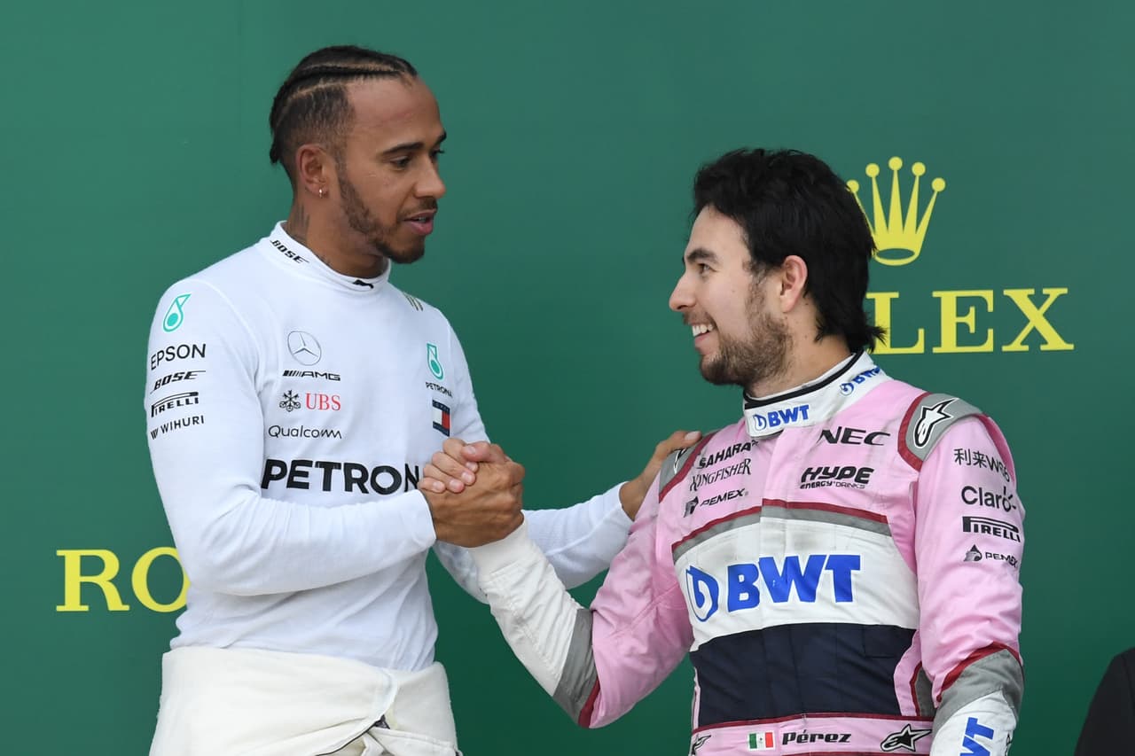 Winner Mercedes' British driver Lewis Hamilton (L) shakes hands with third placed Force India's Mexican driver Sergio Perez as they celebrate on the podium of the Formula One Azerbaijan Grand Prix at the Baku City Circuit in Baku on April 29, 2018. (Photo by Kirill KUDRYAVTSEV / AFP) (Photo credit should read KIRILL KUDRYAVTSEV/AFP via Getty Images)
