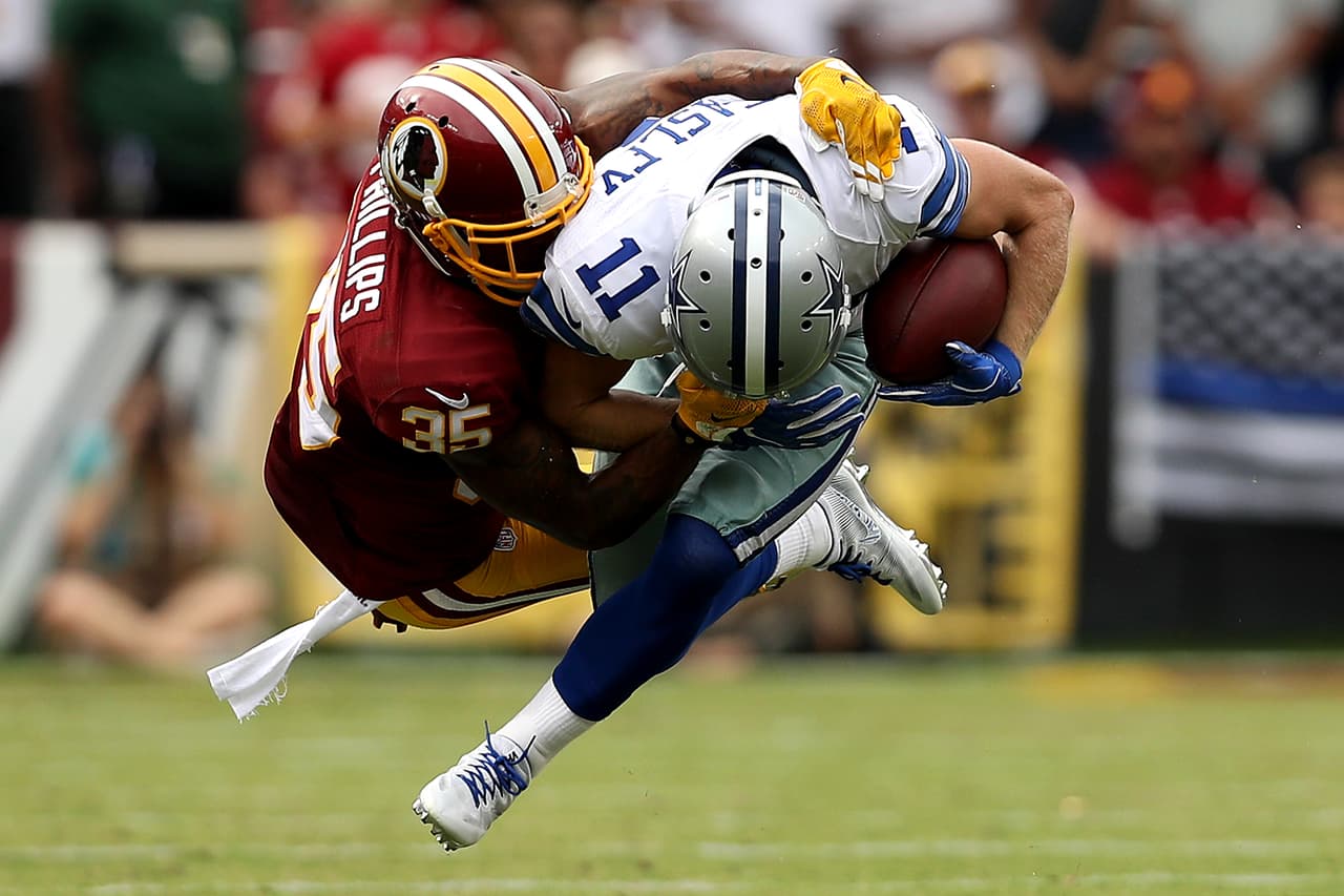 Cole Beasley, receptor de los Cobowys, tomado de la máscara por el defensivo de los Redskins.