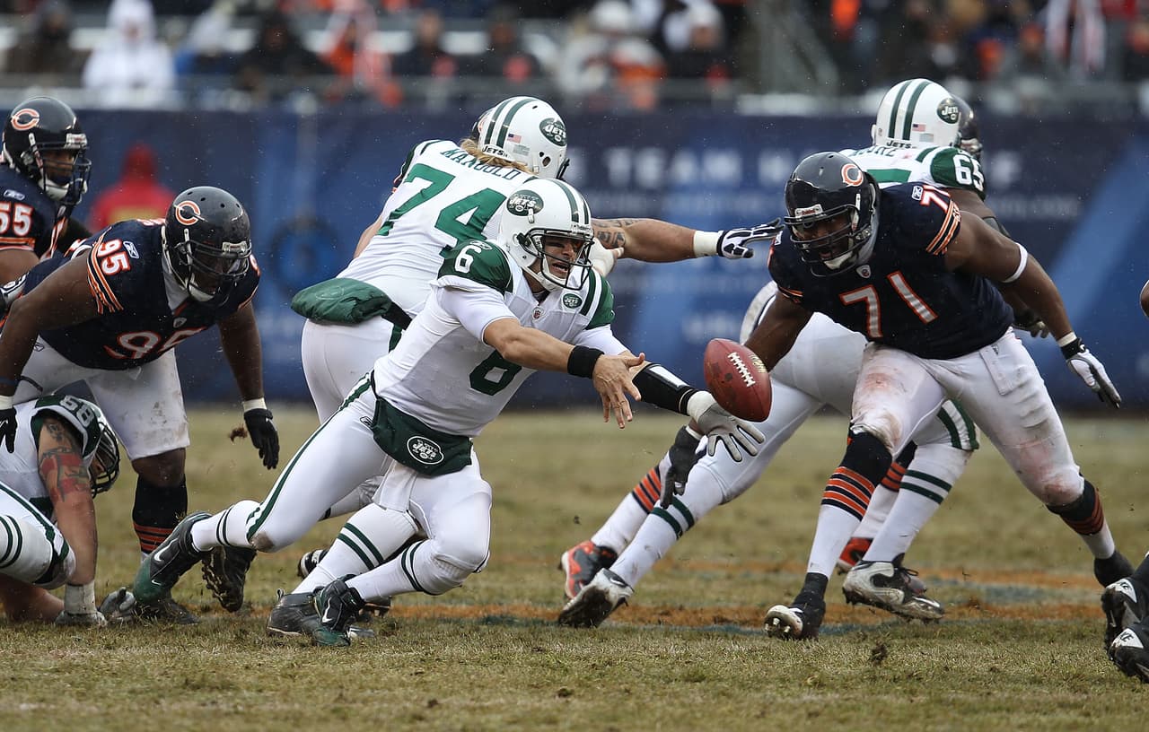 CHICAGO, IL - DECEMBER 26: Mark Sanchez #6 of the New York Jets slips as he tosses the ball to a running back as Anthony Adams #95 and Israel Idonije #71 of the Chicago Bears rush at Soldier Field on December 26, 2010 in Chicago, Illinois. The Bears defeated the Jets 38-34. (Photo by Jonathan Daniel/Getty Images)