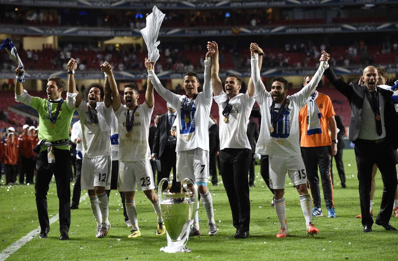 Real Madrid's Brazilian defender Marcelo (2ndL), Real Madrid's midfielder Isco (3rdL), Real Madrid's Portuguese forward Cristiano Ronaldo (C), Real Madrid's defender Daniel Carvajal (2ndR) and Real Madrid's assistant manager Zinedine Zidane celebrate their victory at the end of the UEFA Champions League Final Real Madrid vs Atletico de Madrid at Luz stadium in Lisbon, on May 24, 2014. Real Madrid won 4-1. AFP PHOTO/ FRANCK FIFE (Photo credit should read FRANCK FIFE/AFP via Getty Images)