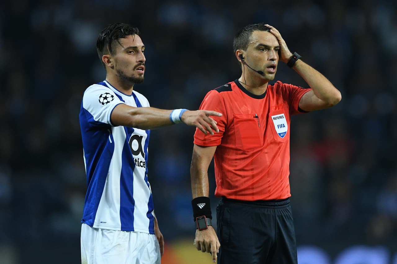 PORTO, PORTUGAL - NOVEMBER 01: Alex Telles (L) of FC Porto and the referee Ovidiu Hategan in action during the UEFA Champions League group G match between FC Porto and RB Leipzig at Estadio do Dragao on November 1, 2017 in Porto, Portugal. (Photo by Octavio Passos/Getty Images)