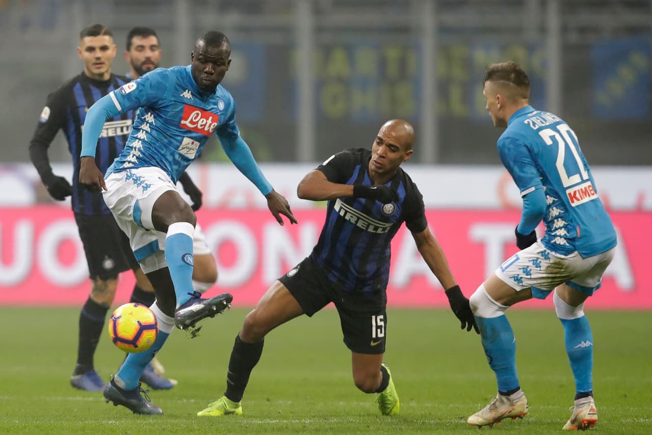 Napoli's Kalidou Koulibaly , left, fights for the ball with Inter Milan's Joao Mario, center during a Serie A soccer match between Inter Milan and Napoli, at the San Siro stadium in Milan, Italy, Wednesday, Dec. 26, 2018. (AP Photo/Luca Bruno)