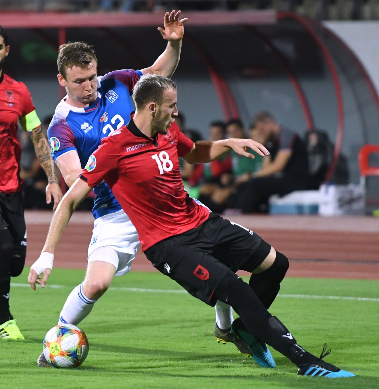 Jon Dadi Boovarsson le rompe la cintura a Ardian Ismajli en el partido contra Albania.