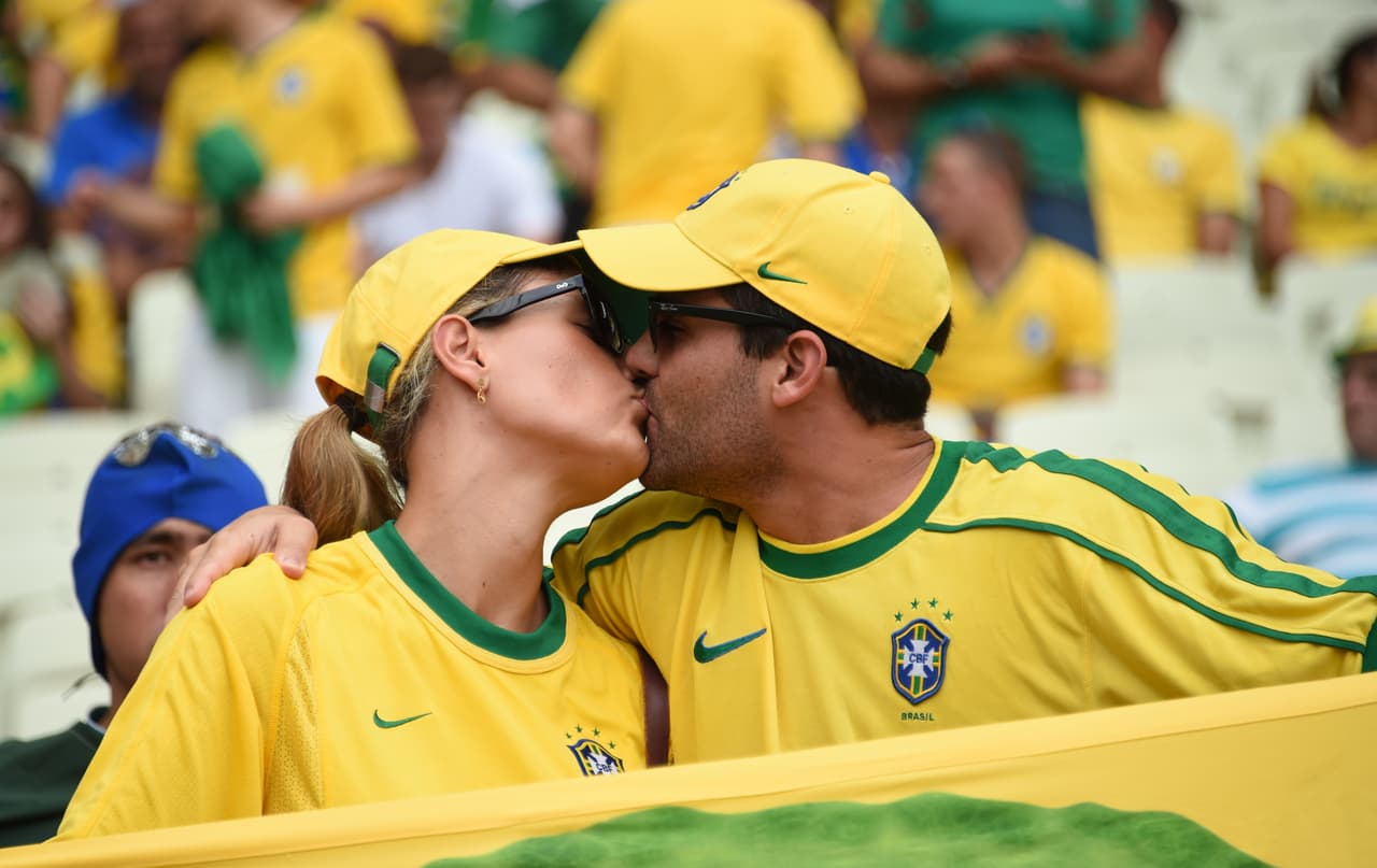 Brazilian supporters kiss prior to a Group A football match between Brazil and Mexico at the Castelao Stadium in Fortaleza during the 2014 FIFA World Cup on June 17, 2014. AFP PHOTO / VANDERLEI ALMEIDA (Photo credit should read VANDERLEI ALMEIDA/AFP/Getty Images)