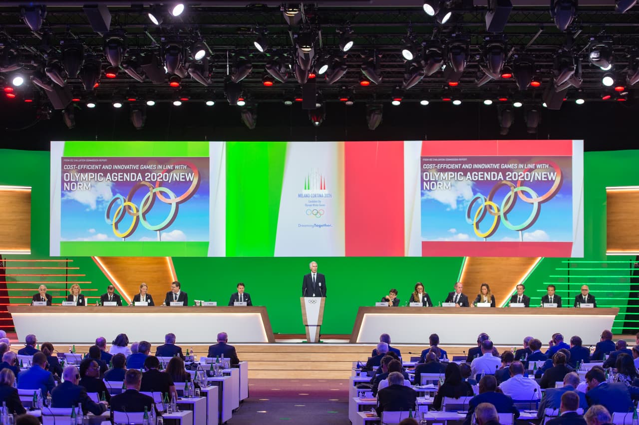 La localidad de Cortina d'Ampezzo había albegrado los Juegos Olímpicos de Invierno de 1956 y más recientemente, Italia organizó las mismas justas en Torino 2006.