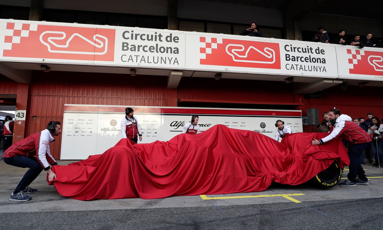 Personal del equipo se preparaba a así para revelar la identidad del flamante Alfa Romeo en la presentación del equipo en Montmeló, en las cercanías de Barcelona.