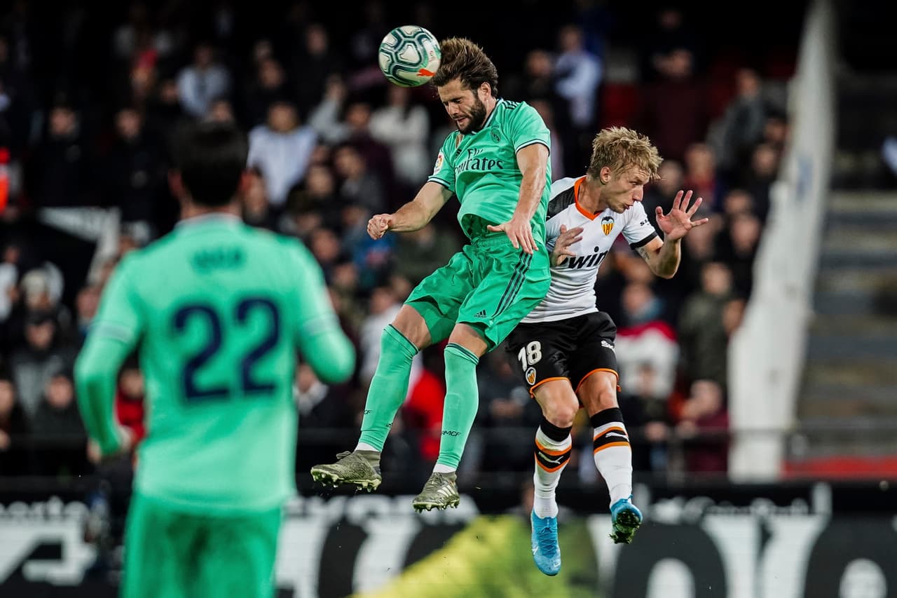 Wass intenta ganar un balón aéreo pero es amargado por el corte perfecto de la defensa madridista