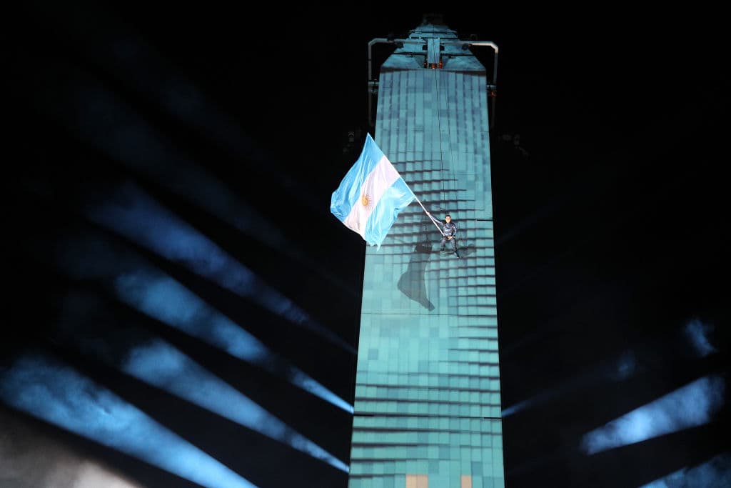 Un artista escalando por el Obelisco con la bandera argentina también fue atracción en la ceremonia.