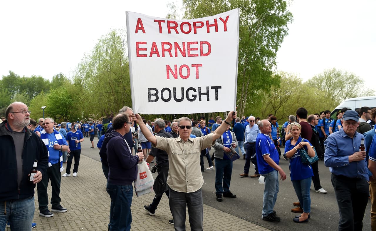Este satisfecho aficionado del conjunto 'blue' porta un letreto con la leyenda "Un trofeo ganado y no comprado".