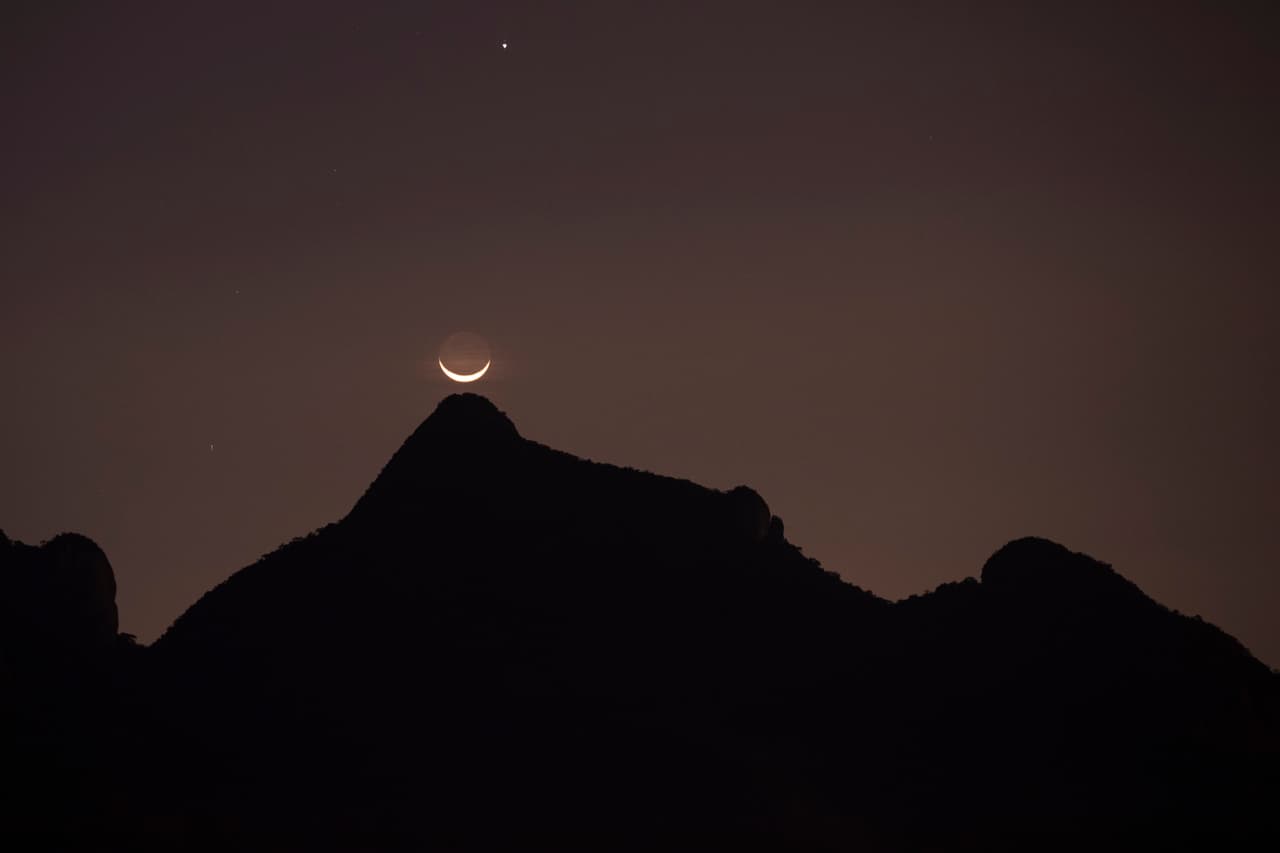 La Luna se asoma por encima de un pico alrededor de Rio de Janeiro durante la Ceremonia de Inauguración.