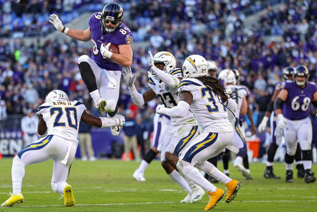 BALTIMORE, MARYLAND - JANUARY 06: Tight end Mark Andrews #89 of the Baltimore Ravens leaps over defensive back Desmond King #20 of the Los Angeles Chargers in the fourth quarter during the AFC Wild Card Playoff game at M&T Bank Stadium on January 06, 2019 in Baltimore, Maryland. (Photo by Patrick Smith/Getty Images)