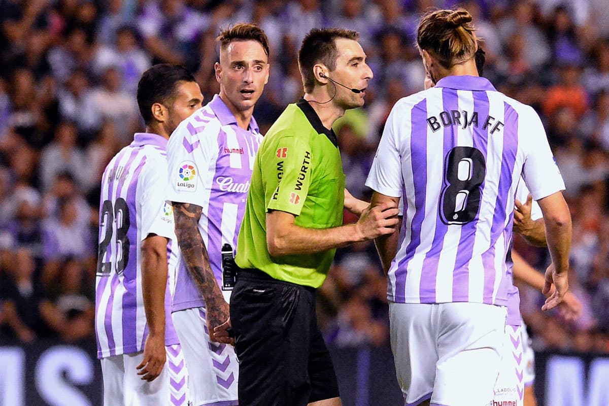 El árbitro Ricardo de Burgos (centro) es rodeado por los jugadores del Valladolid que se mostraron en desacuerdo por la jugada de gol anulada.