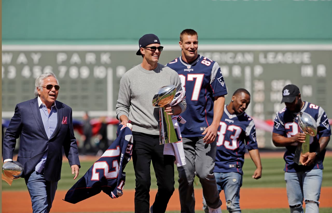 New England Patriots, from left, owner Robert Kraft, and players Tom Brady, Rob Gronkowski, Dion Lewis and James White carry the team's five Super Bowl trophies during Boston Red Sox Home Opening Day ceremonies at Fenway Park, Monday, April 3, 2017, in Boston. The Red Sox face the Pittsburgh Pirates in the baseball game. (AP Photo/Elise Amendola)