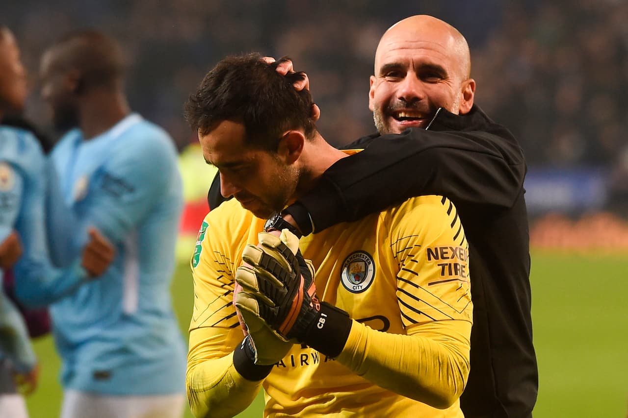 Manchester City's Spanish manager Pep Guardiola (R) celebrates on the pitch with Manchester City's Chilean goalkeeper Claudio Bravo (L) after winning after the penalty shoot out in the English League Cup quarter-final football match between Leicester City and Manchester City at King Power Stadium in Leicester, central England on December 19, 2017. / AFP PHOTO / PAUL ELLIS / RESTRICTED TO EDITORIAL USE. No use with unauthorized audio, video, data, fixture lists, club/league logos or 'live' services. Online in-match use limited to 75 images, no video emulation. No use in betting, games or single club/league/player publications. / (Photo credit should read PAUL ELLIS/AFP/Getty Images)