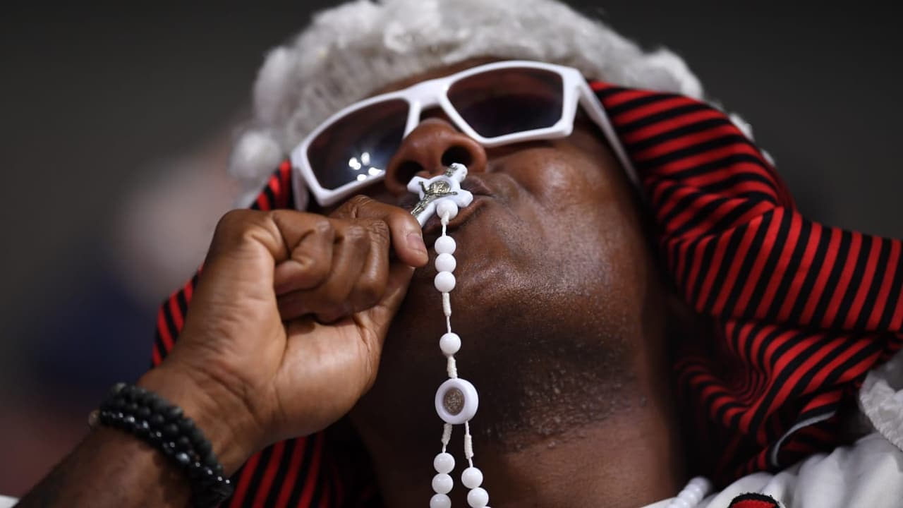 Aficionado al Flamengo besa su rosario.