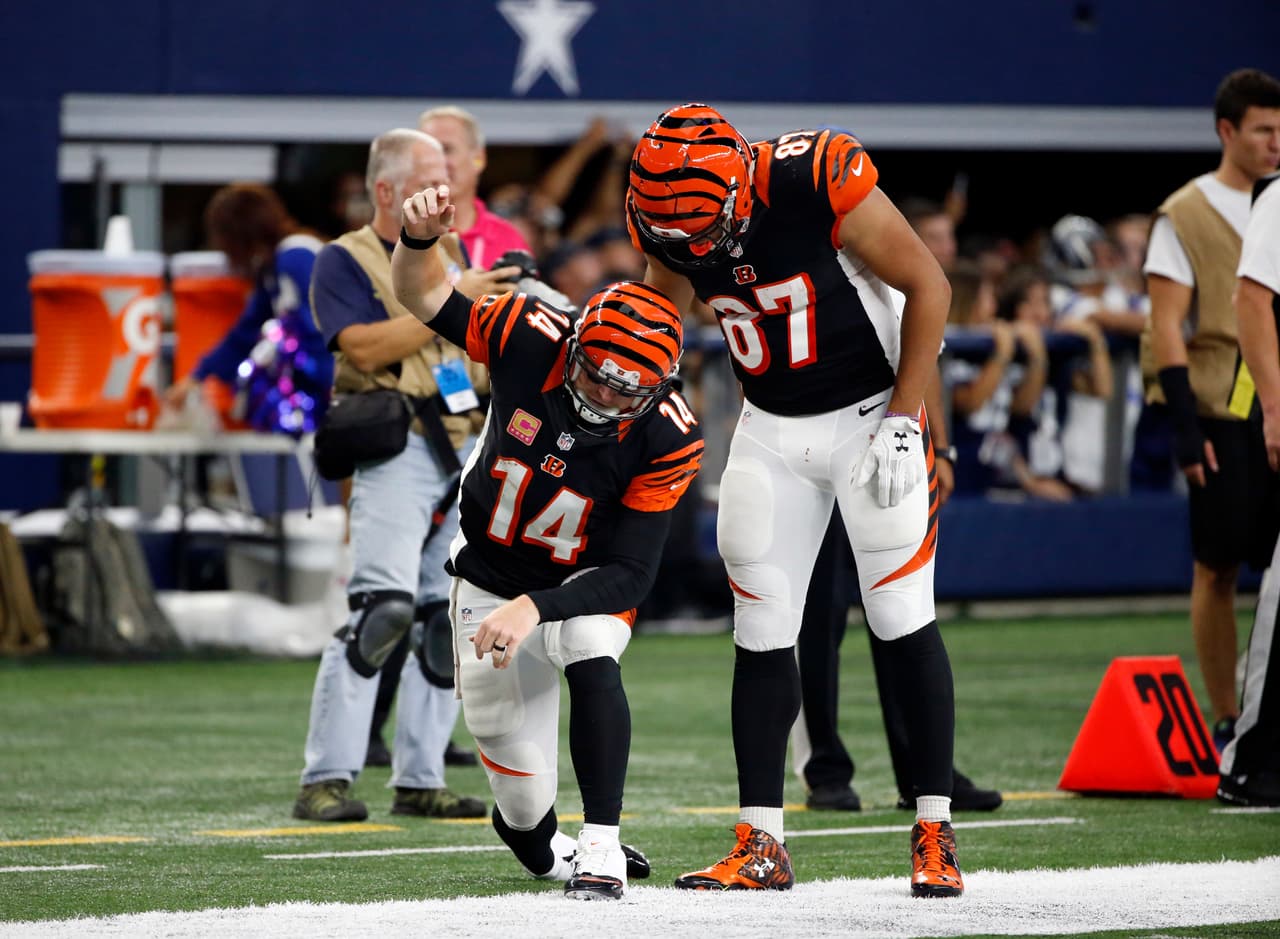 Cincinnati Bengals quarterback Andy Dalton (14) gets up slowly after being tackled with help from tight end C.J. Uzomah in the second half of an NFL football game against the Dallas Cowboys on Sunday, Oct. 9, 2016, in Arlington, Texas. (AP Photo/Ron Jenkins)