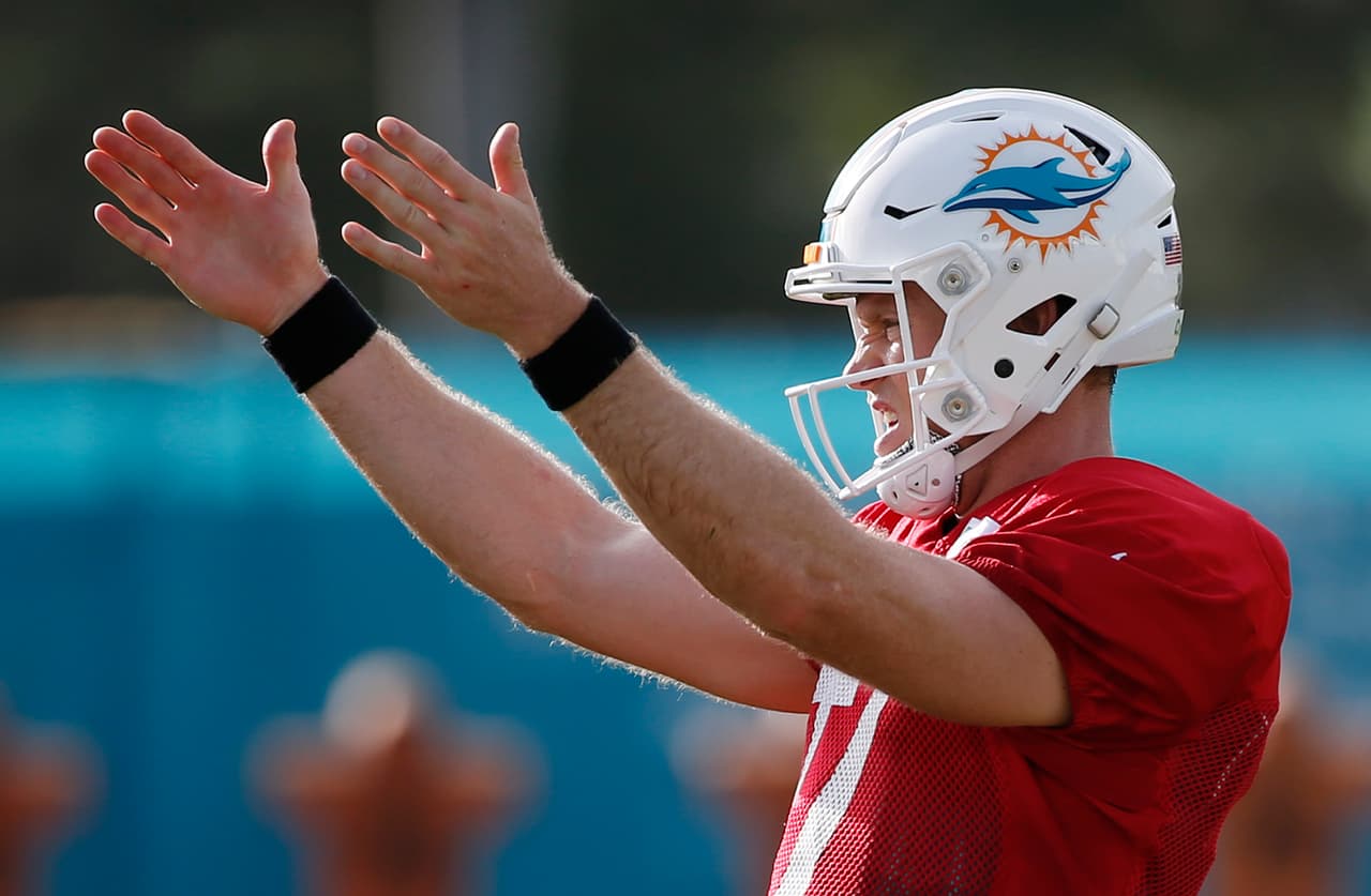 Miami Dolphins quarterback Ryan Tannehill gestures as he runs through drills during an NFL football training camp, Thursday, Aug. 3, 2017, at the Dolphins training facility in Davie, Fla. Tannehill left practice after his left knee appeared to buckle on a scramble and he fell without being hit. (AP Photo/Wilfredo Lee)