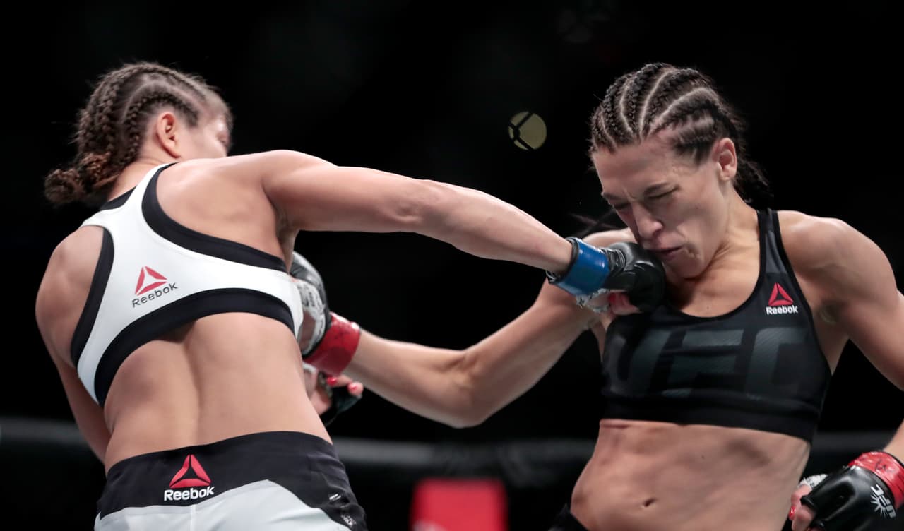 Karolina Kowalkiewicz, left, lands a shot on Joanna Jedrzejczyk during a women's strawweight title mixed martial arts bout at UFC 205, Saturday, Nov. 12, 2016, at Madison Square Garden in New York. (AP Photo/Julio Cortez)