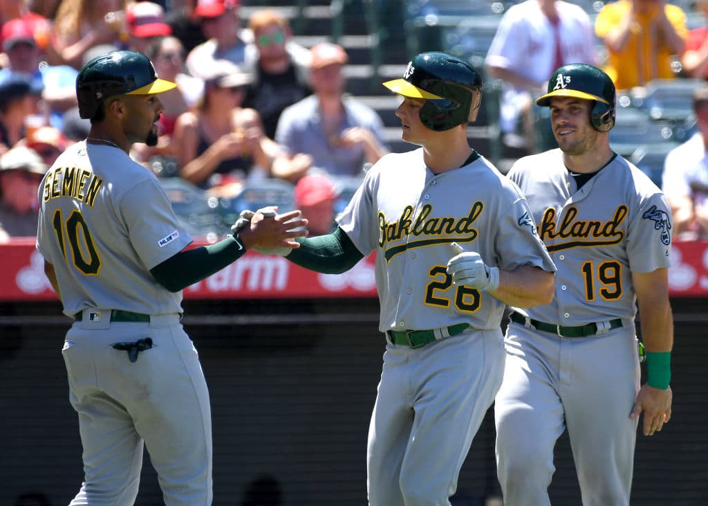 ANAHEIM, CA - JUNE 30: Matt Chapman #26 is congratulated by Marcus Semien #10 and Josh Phegley #19 of the Oakland Athletics after hitting a three run home run in the fifth inning of the game against the Los Angeles Angels at Angel Stadium of Anaheim on June 30, 2019 in Anaheim, California. (Photo by Jayne Kamin-Oncea/Getty Images)