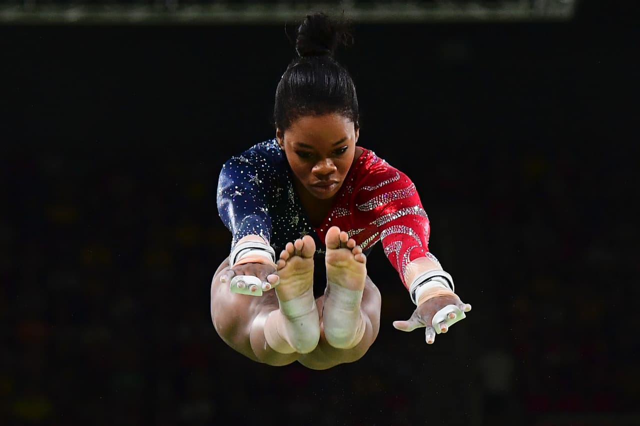 Gabrielle Douglas vuela antes de tomar la barra durante una de sus presentaciones. 
<br>