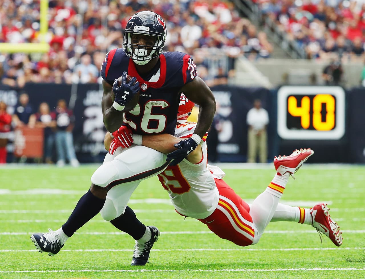 HOUSTON, TX - SEPTEMBER 18: Lamar Miller #26 of the Houston Texans runs away from the tackle of Daniel Sorensen #49 of the Kansas City Chiefs in the second quarter of their game at NRG Stadium on September 18, 2016 in Houston, Texas. (Photo by Scott Halleran/Getty Images)