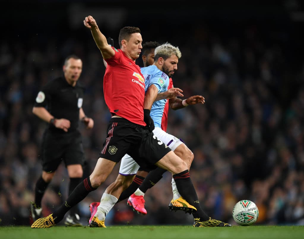 Sergio Aguero del Manchester City tratando de ganar el balón ante Nemanja Matic y Fred del Manchester United.