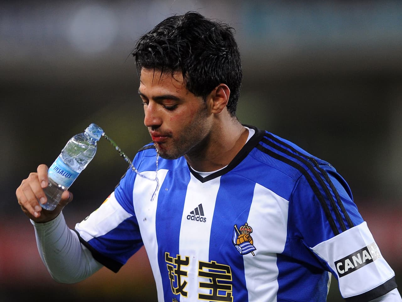 Real Sociedad's Mexican forward Carlos Vela cleans his mouth after receiving a hit during the Spanish league football match Real Sociedad vs Atletico de Madrid at the Anoeta stadium in San Sebastian on November 9, 2014. Real Sociedad won 2-1. AFP PHOTO/ RAFA RIVAS (Photo credit should read RAFA RIVAS/AFP/Getty Images)
